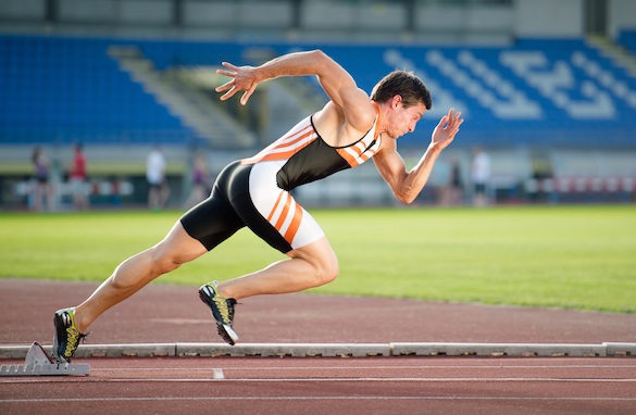 Sprinter leaving starting blocks on the running track. Explosive start.